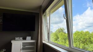 a large window in a room with a tv and a window at Kovarnu street apartment in Cēsis