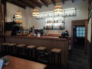 a restaurant with a bar with stools at Apartamentos Cuevas del Mar in Nueva de Llanes