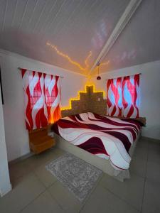 a bedroom with a bed with red and white sheets at GranjaKatKery in Cerro Azul +8 photos