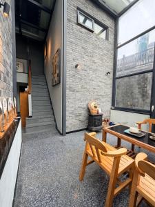 ein Zimmer mit Tisch und Stühlen und einer Backsteinwand in der Unterkunft Interlude Inn, Boutique Art Retreat, Cultural Experience, Artisan Breakfast in Fenghuang + 66 Fotos