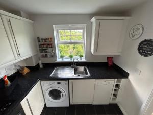 a kitchen with a sink and a washing machine at Light & Airy flat, Amazing view in Whitefield +14 photos
