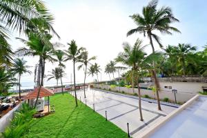 Blick auf den Pool des Resorts mit Palmen in der Unterkunft Tidal Crest in Kundapura