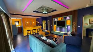 a living room with two blue couches and a kitchen at Prestige Majorelle Résidence Prestige Majorelle in Ngaparou