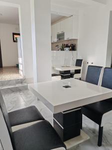a dining room with a white table and chairs at Vila Cezar in Gornja Toplica