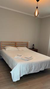 a bedroom with a white bed with two towels on it at Ramboia Guest House in São Pedro do Sul