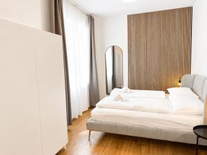 a living room with two beds and a mirror at Cosy Penzing Vienna in Vienna