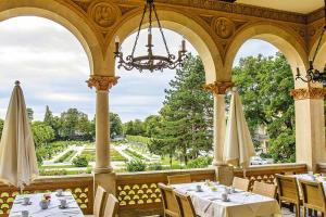 a dining room with tables and a view of a garden at Pytloun Schlosshotel Weikersdorf in Baden
