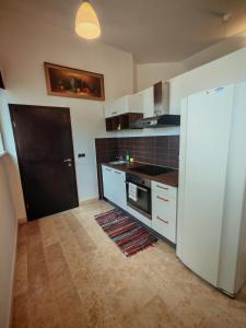 a kitchen with white cabinets and a black door at WoW sleeping in Miklavž na Dravskem Polju