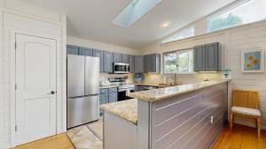 a kitchen with gray cabinets and a white refrigerator at Dewey Beach 102 Jersey St in Dewey Beach