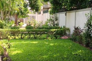 a yard with a white fence and green grass at Royal Garden Residence in Apégame