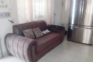 a brown couch in a kitchen with a refrigerator at Royal Garden Residence in Apégame