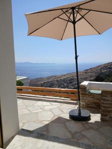 ein Sonnenschirm auf einer Terrasse in der Unterkunft Alchemis in Kardhianí