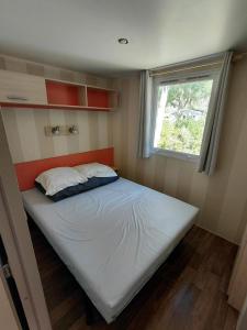 a bed in a small room with a window at Le petit paradis de la roque d'antheron in Jean-Jean