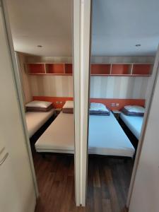 a small room with two beds and a mirror at Le petit paradis de la roque d'antheron in Jean-Jean