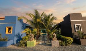 a blue house with palm trees in front of it at Prestige Majorelle Résidence Prestige Majorelle in Ngaparou