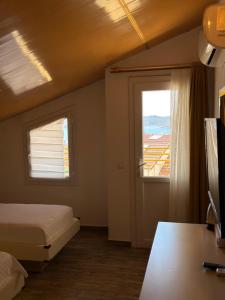 a bedroom with a bed and a window with a view at Limon Pansiyon in Kaş