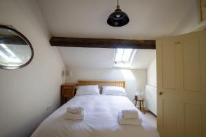 a bedroom with a white bed with two towels on it at The Forge in Bakewell