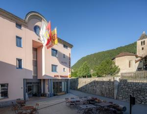 a hotel with tables and chairs in a courtyard at Hotel Restaurant Alte Brauerei in Celerina