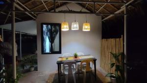 a room with a table and two chairs and lights at Anchor Doods in Romblon