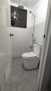 a white bathroom with a toilet and a sink at Anchor Doods in Romblon