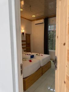 a bedroom with two beds with flowers on them at Reethi Stay Omadhoo in Reethi Rah