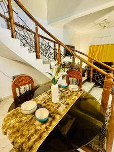 a table with bowls on it in a room with stairs at Fernwood stays in Haidar Sāhibgūda