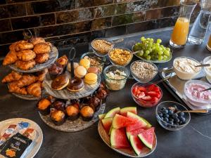 ein Tisch mit vielen Tellern voller Speisen und Obst in der Unterkunft Hotel het Dok in IJmuiden
