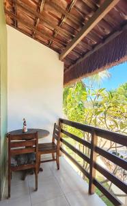 a table and a bench on a balcony at Pousada Recanto dos Milagres in São Miguel dos Milagres