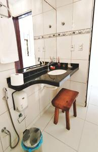 a bathroom with a sink and a mirror and a stool at Pousada Recanto dos Milagres in São Miguel dos Milagres +53 photos