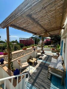 a patio with chairs and a wooden pergola at Capri Joy Apartments in Capri