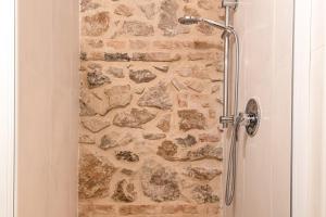 a bathroom with a shower with a stone wall at Appartamenti Monte Selce in Monselice +33 photos