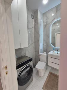 a bathroom with a washing machine and a toilet at ЖК Geneva in Astana