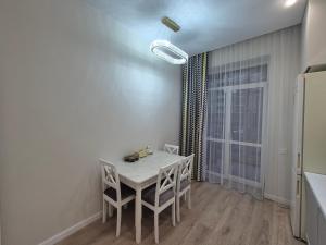 a dining room with a white table and a window at ЖК Geneva in Astana +3 photos
