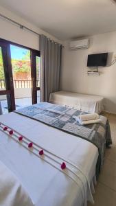 a bedroom with two beds with red roses on them at Pousada Recanto dos Milagres in São Miguel dos Milagres