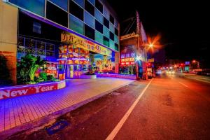 una calle de la ciudad por la noche con edificios y luces en Wsb Motel-Rende en Tainan