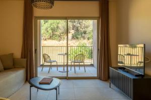 a living room with a couch and a sliding glass door at Résidence San Petru - 4 étoiles in Porto-Vecchio