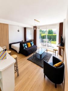 a living room with a bed and a couch at Appart Omaha Beach in Port-en-Bessin-Huppain +5 photos