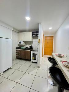 a kitchen with white appliances and a white tiled floor at WestFlat - BarretoStays 01 in Mossoró