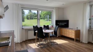 a dining room with a table and chairs and a window at Ferienwohnungen Irmengard in Bernau am Chiemsee