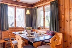 a dining room with a table and chairs and windows at Apartment Bergdohle in Amden +9 photos