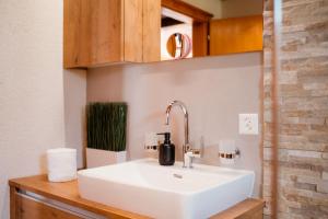 a bathroom with a white sink in a room at Apartment Bergdohle in Amden