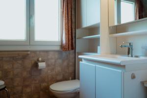 a bathroom with a toilet and a sink at Chalet Engihalde in Amden +17 photos