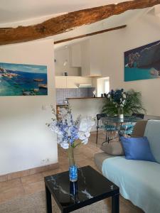a living room with a couch and a table with flowers at Le bleu des toits in Lodève +5 photos