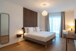ein Hotelzimmer mit Bett und Spiegel in der Unterkunft Pattùs Hôtel in Saint Aubin Sauges