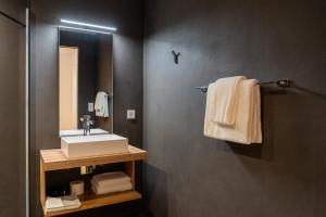 ein Badezimmer mit Waschbecken, Spiegel und Handtüchern in der Unterkunft Pattùs Hôtel in Saint Aubin Sauges + 61 Fotos
