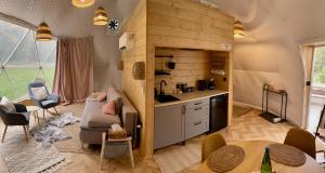 a living room with a couch and a kitchen at beGLAMP - Glamping nad Zalewem Próba in Brzeźnio