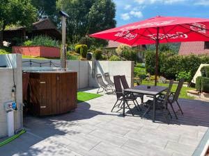 a patio with a table and chairs and an umbrella at Penzion Ján in Habovka