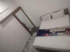 a bed in a room with a mirror next to it at HOTEL GILL TOWER (GRAND) in Hanumāngarh