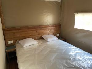 a bed in a room with two pillows on it at lodge lavallee in Belvédère