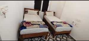 two twin beds in a small room with at HOTEL GILL TOWER (GRAND) in Hanumāngarh
